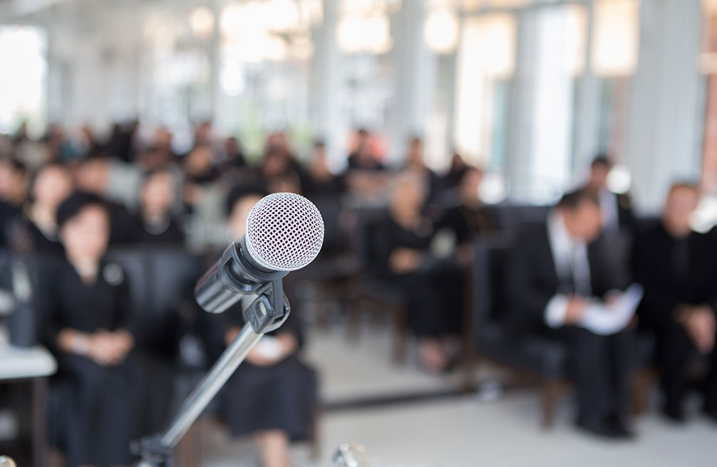 Microphones on the funeral podium and people wearing black in the church